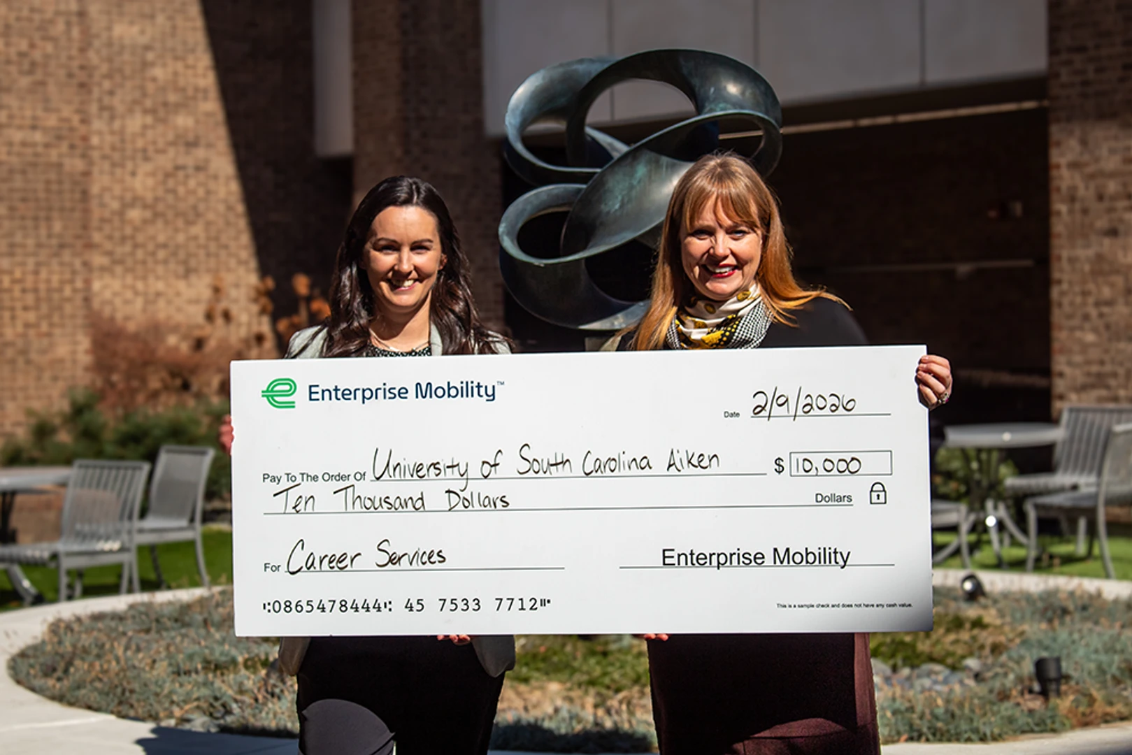 From left, Chelsey Roulier presents Sumner Markwalter a check from The Enterprise Mobility Foundation™ that recently invested $10,000 in Pacers’ success with a grant to USCA’s Office of Career Services