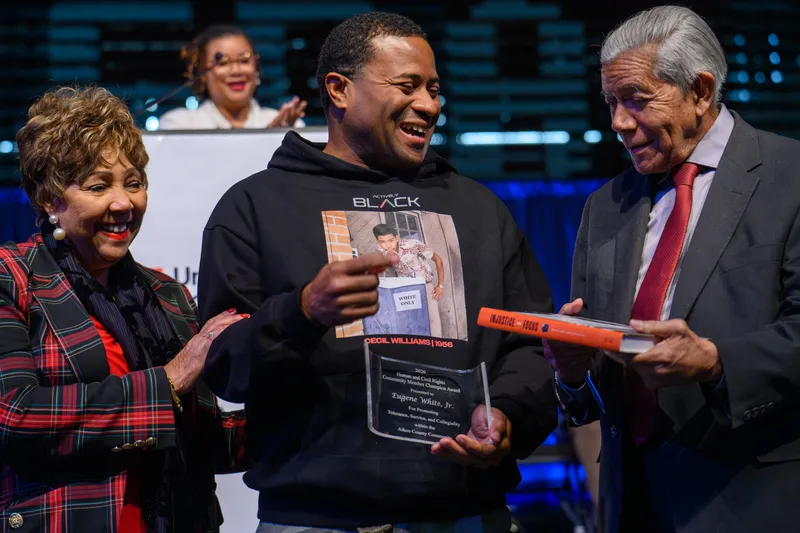 Eugene White Jr., center, recipient of the 2025 Human and Civil Rights Community Champion Award, middle, stands with MLK Community Celebration Chairwoman Gail Diggs, left, and event speaker Cecil Williams, right.