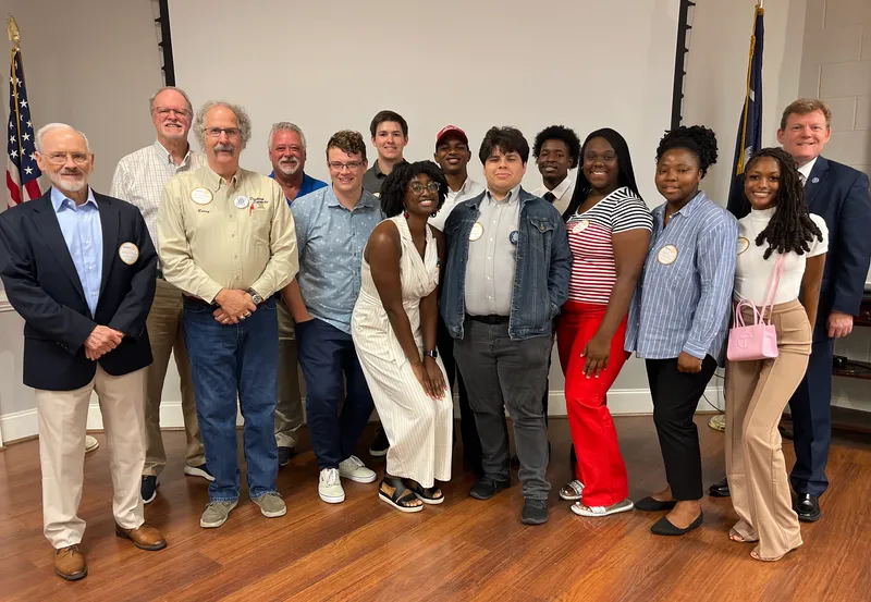 Barry Hudson, one of three of the cybersecurity professors advising the group, stands alongside the cybersecurity interns.