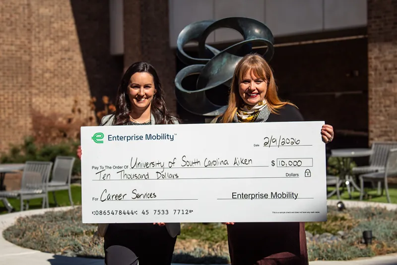 From left, Chelsey Roulier presents Sumner Markwalter a check from The Enterprise Mobility Foundation™ that recently invested $10,000 in Pacers’ success with a grant to USCA’s Office of Career Services