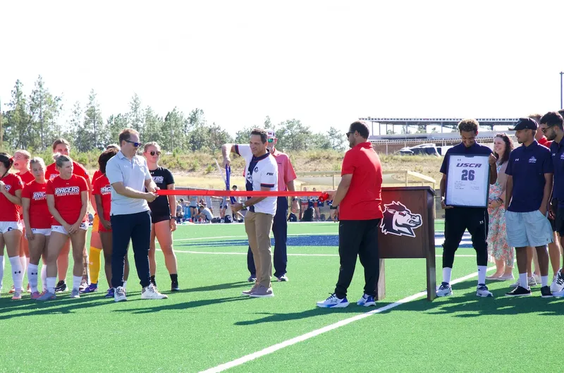 Dr. Daniel Heimmermann, USCA's chancellor, joins in on the ribbon cutting of the new field