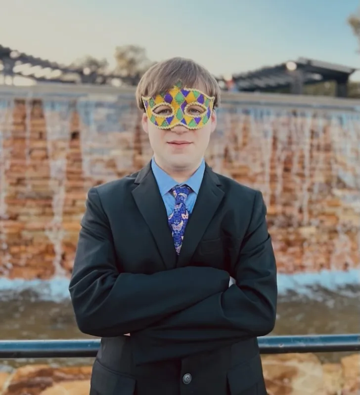 Ripp Laborde wearing a Mardi Gras mask and a suit
